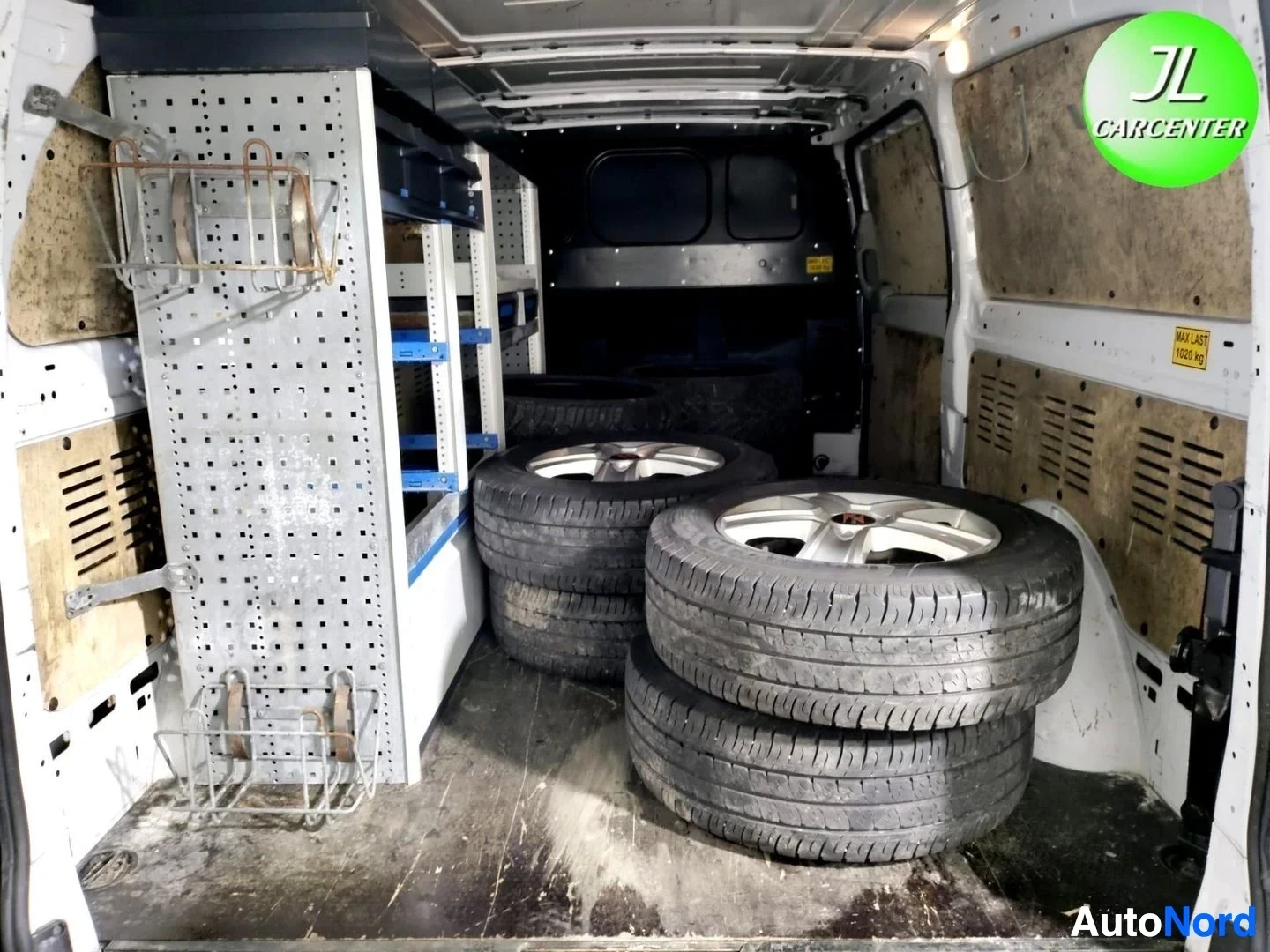 Yksityiskohta: Auton tavaratilassa on renkaita ja varusteita hyllyissä.
