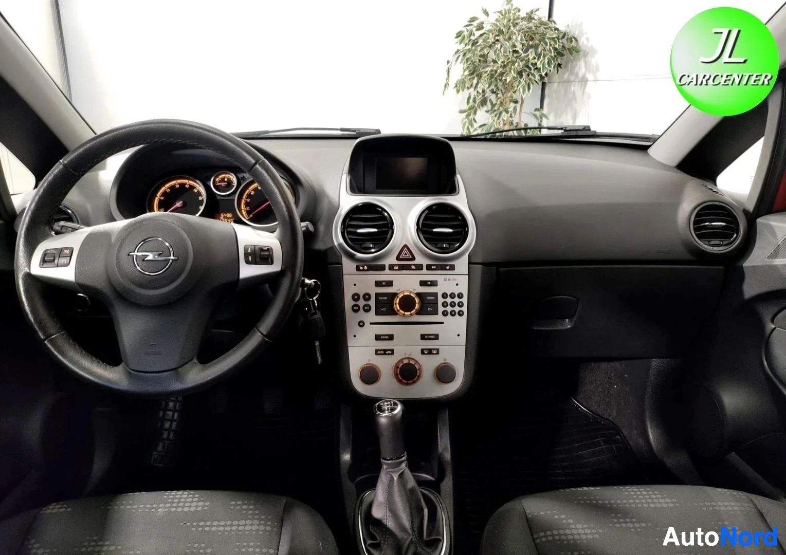 Yksityiskohta: Ohjaamo vasemmalta: Opel-ohjauspyörä, mittaristo, keskinäytöllinen radio ja manuaalivaihteen vapaa