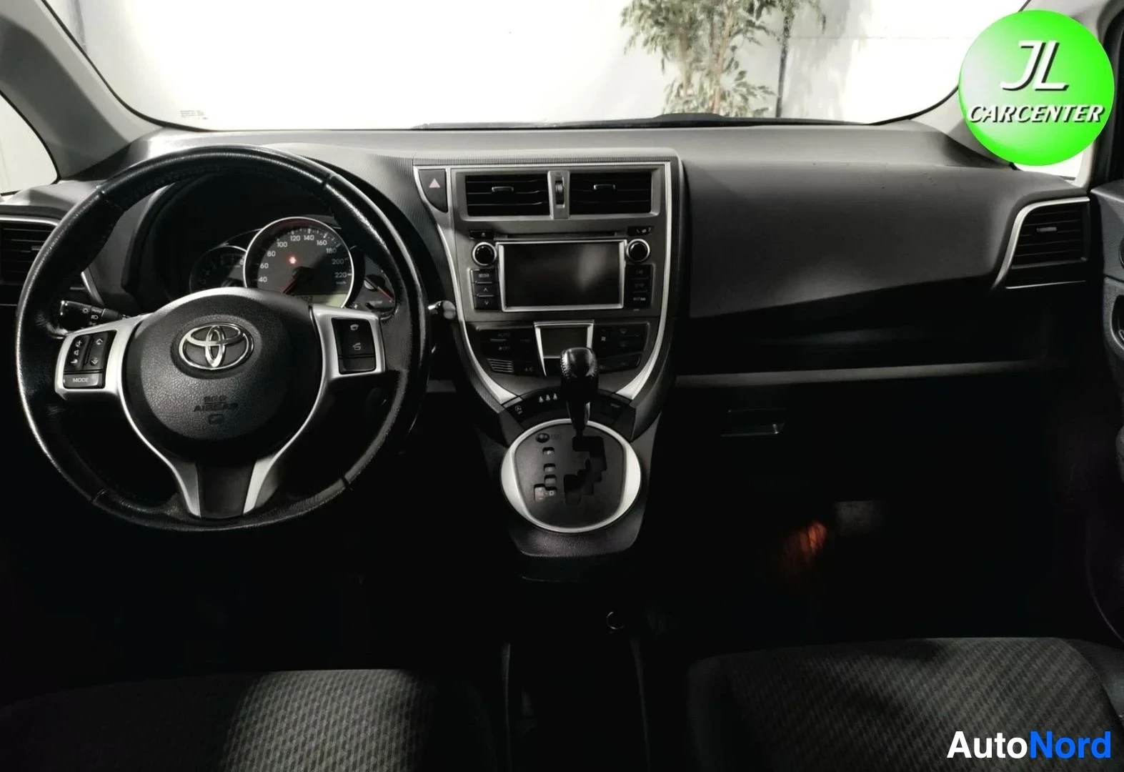 Muu: Kojelauta: Toyota-ohjauspyörä ja mittaristo, keskikonsolissa kosketusnäyttö ja automaattivaihteen valitsin.