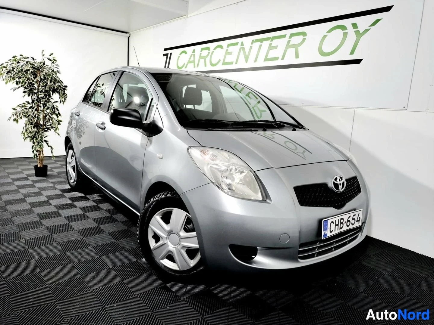 Etuviisto, nokka oikealle: Toyota Yaris -henkilöauton etukulmakuva hopeisena sisätiloissa