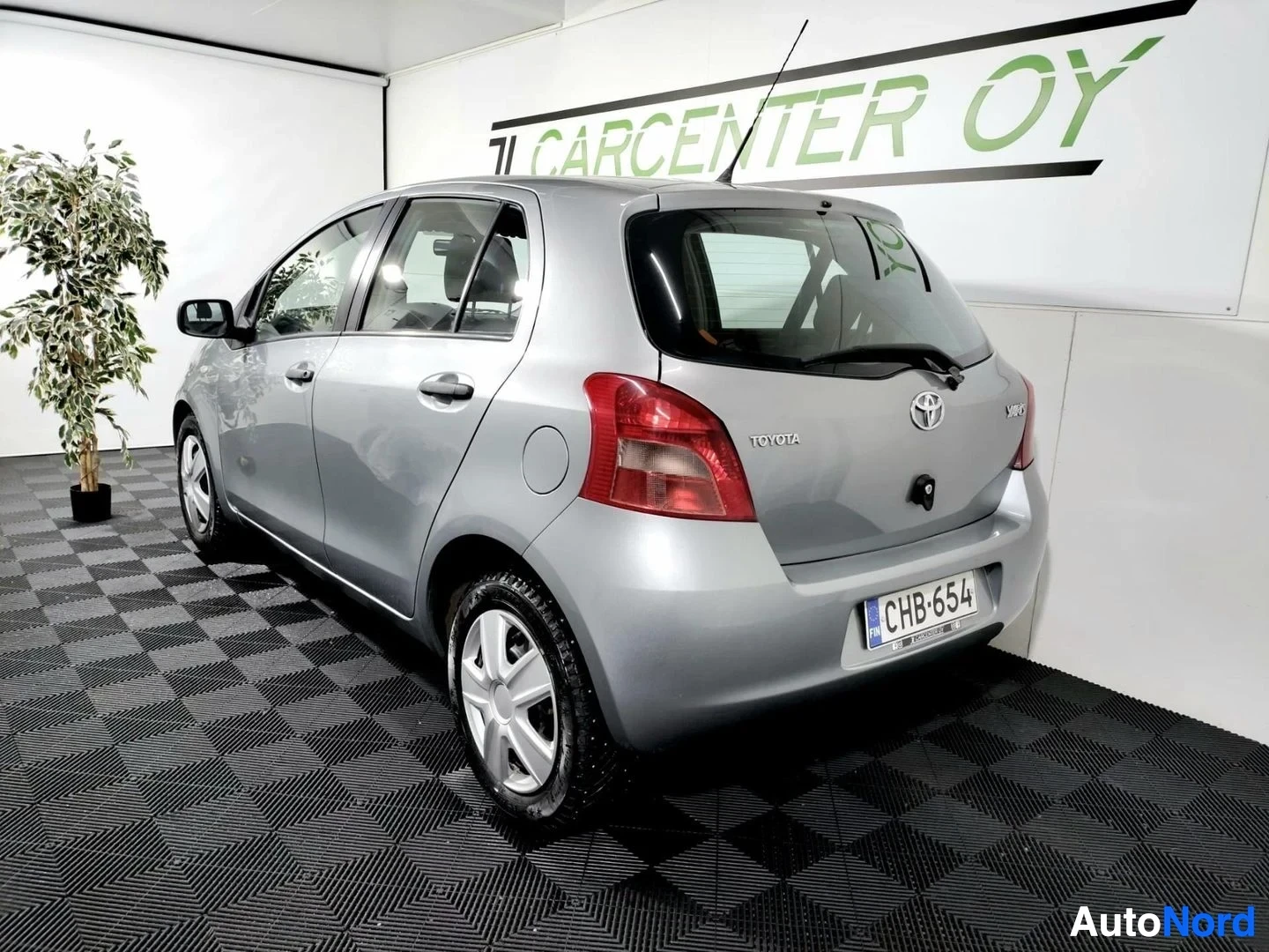 Takaviisto: Hatchback-korinen Toyota takaviistosta oikealta kuvattuna; rekisterikilpi, Toyota-merkintä takaluukussa.