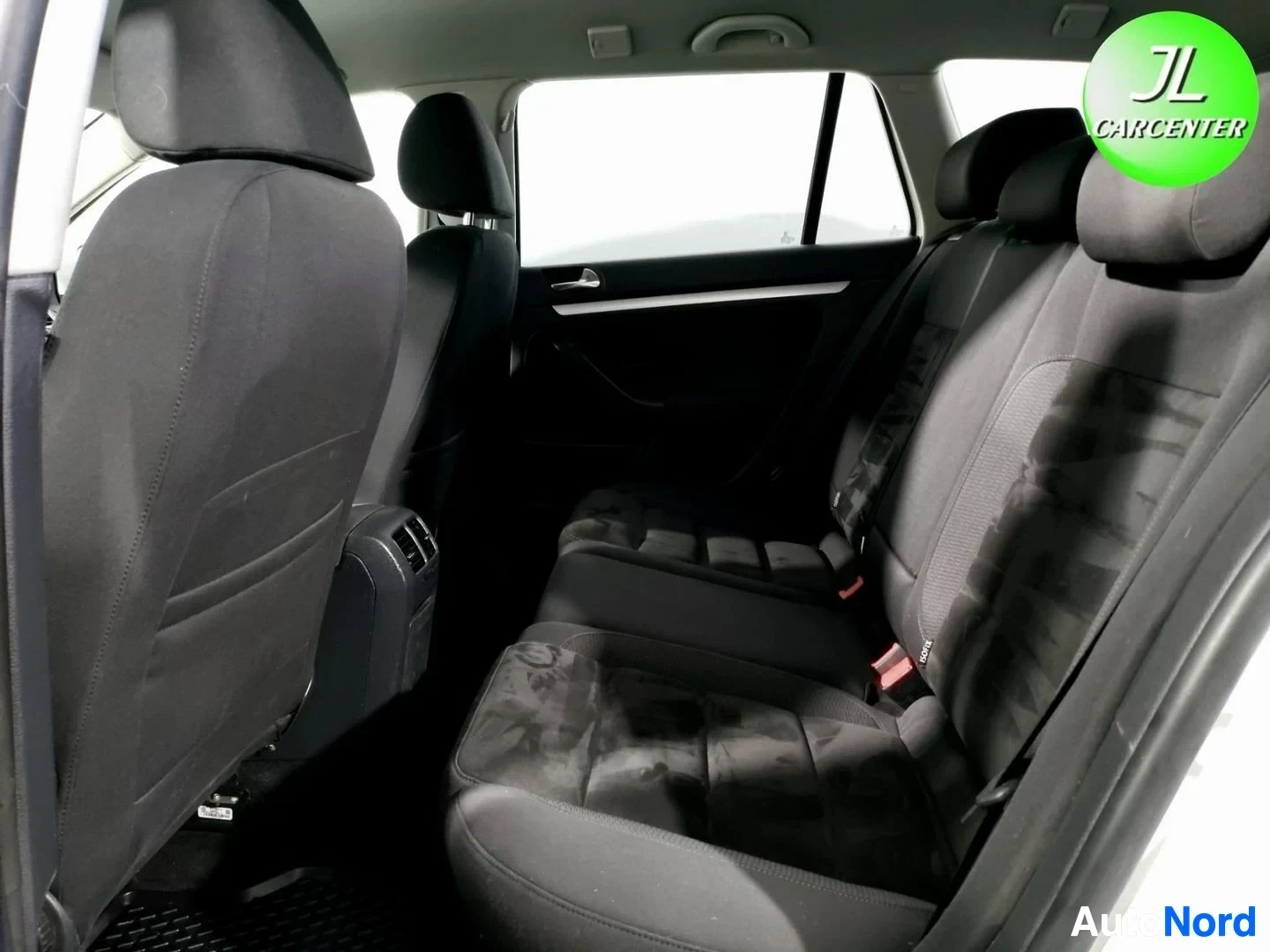 Muu: Takaistuimet auton sisältä kuvattuna: tummat kangasistuimet ja takaosaan vievä käytävä.