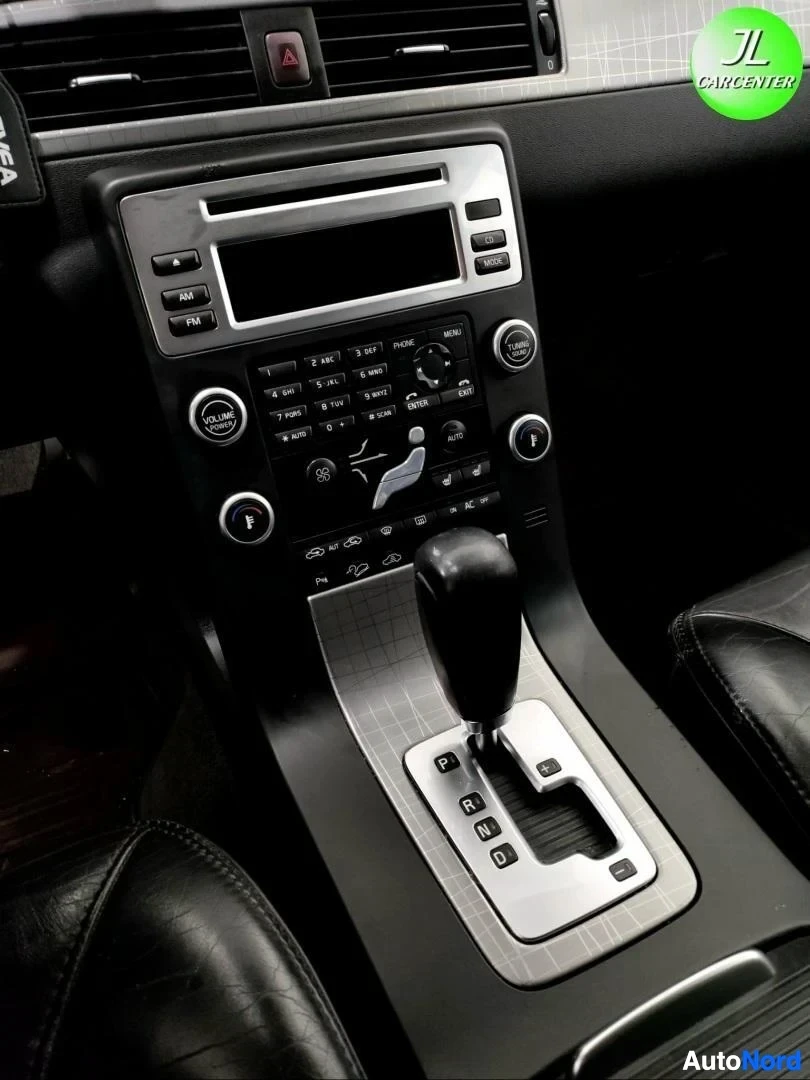 Ohjaamo: Keskitunnus: radio, ilmastointisäädöt ja automaattivaihteen valitsin (P R N D).
