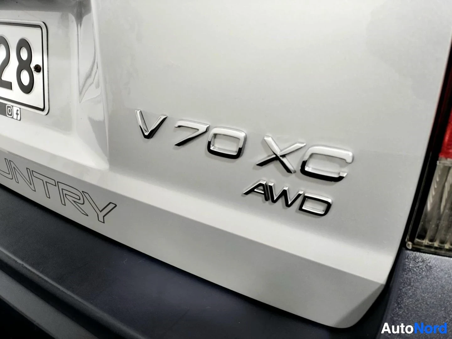 Yksityiskohta: Volvo V70 XC AWD -tunnus takaluukussa, osa rekisterikilvestä näkyvissä