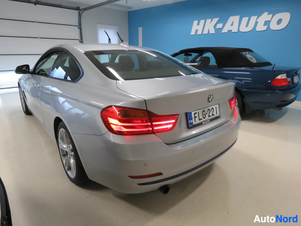 Takaviisto: Hopeanharmaa BMW-coupé takaa kolmannesnurkkakulmasta kuvattuna autotallissa, rekisterikilpi.