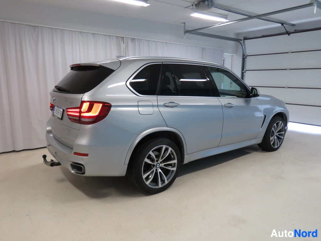 Takaviisto: BMW X5 takakulmasta, takavalot ja irrotettava vetokoukku näkyvissä