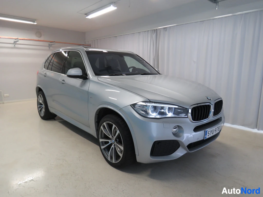 Etuviisto, nokka oikealle: Hopeanharmaa BMW X5 etukulmasta oikealta, rekisterikilpi