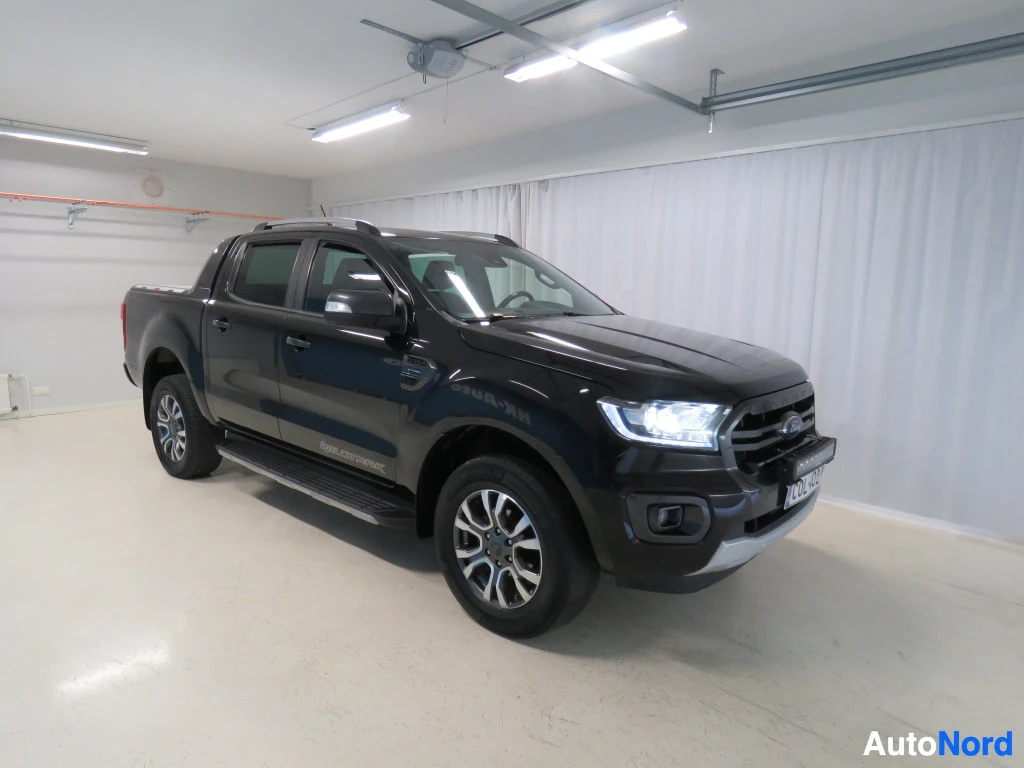 Etuviisto, nokka oikealle: Musta Ford Ranger -pickup kolmeneljännäkymästä edestä oikealta autotallissa.