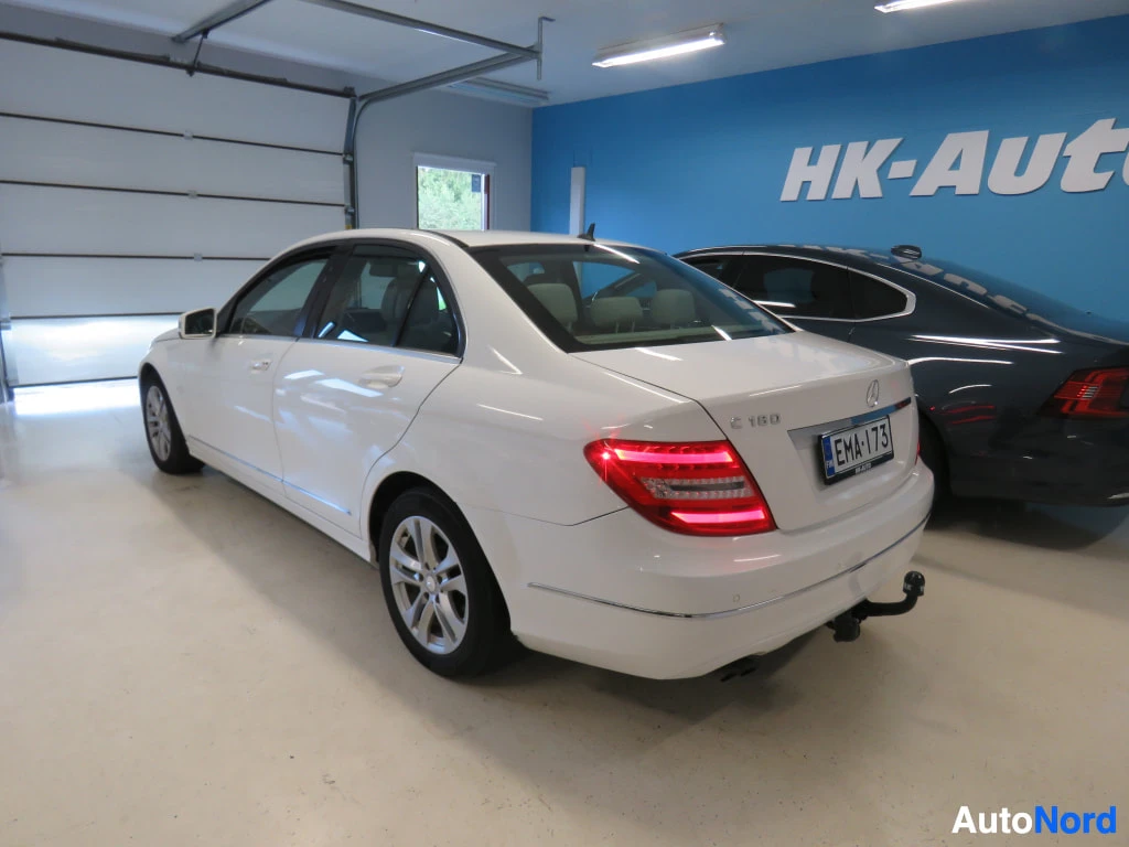 Takaviisto: Valkoisen Mercedes-Benz C-sarjan sedanin takaosa ja oikea kylki kuvattuna vinosti takaa.
