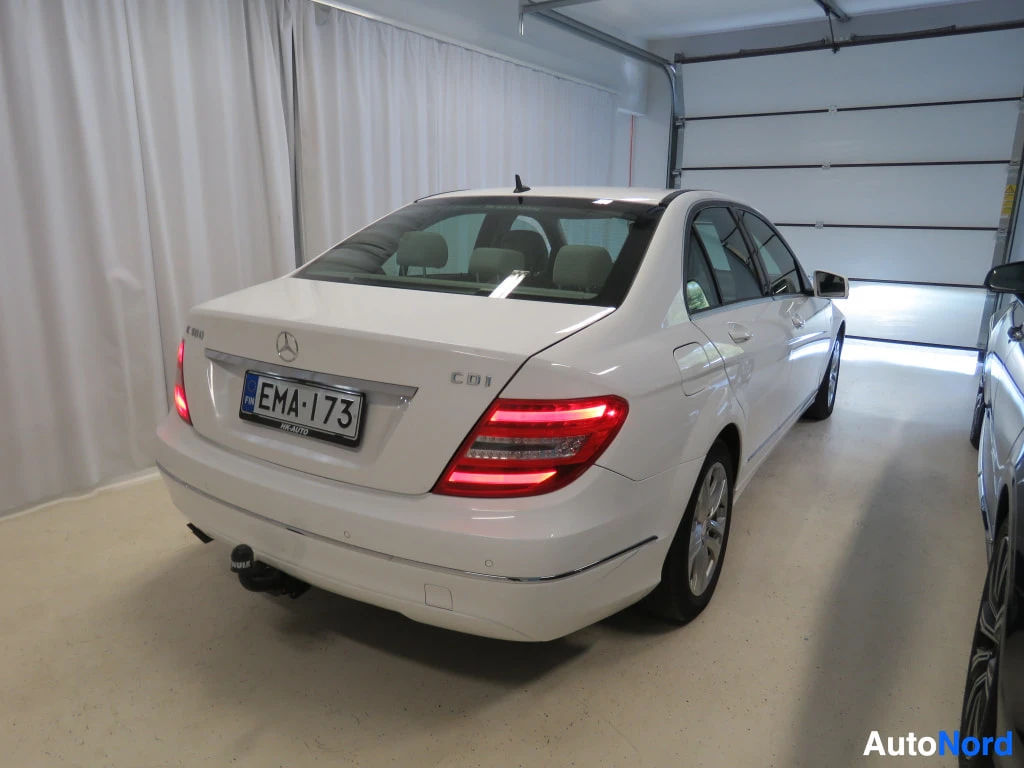 Takaviisto: Valkoisen Mercedes-Benz C-sarjan auton takapää ja kylki kuvattuna takaa vinosti.