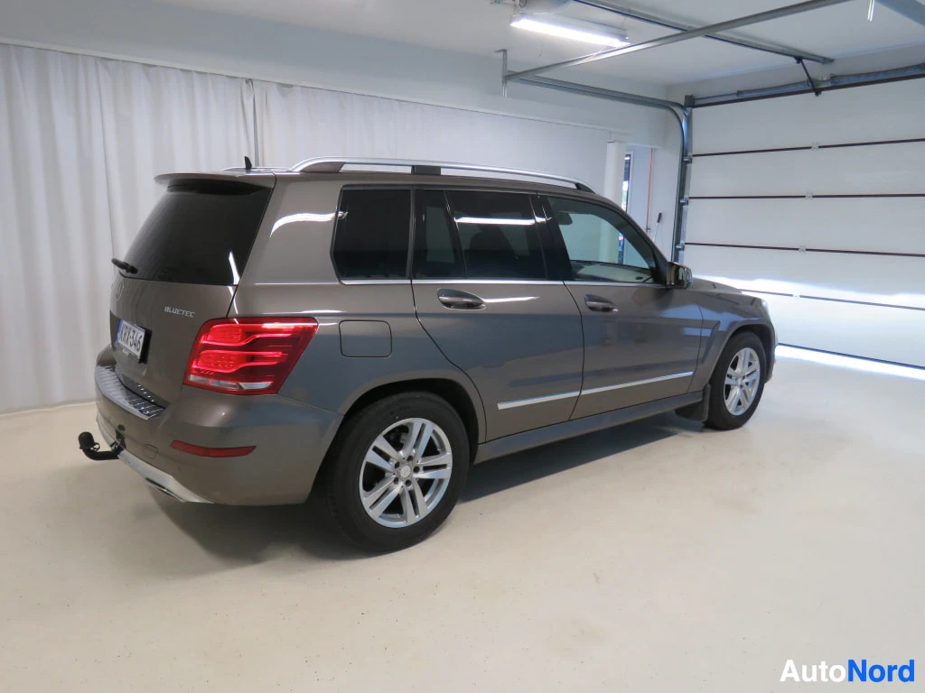 Takaviisto: Mercedes-Benz GLK:n takakulmanosto autotallissa: takapää, kylki, kattonauhake, vetokoukku ja BLUETEC-merkintä näkyvät valkoista verhoa ja autotallin ovea vasten