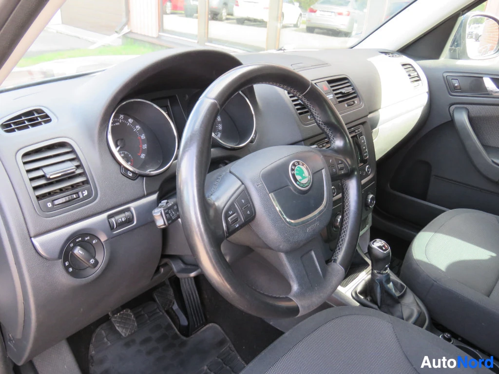 Edestä: Skoda-merkkinen ohjauspyörä, mittaristo ja manuaalivaihteiston vaihdekeppi.