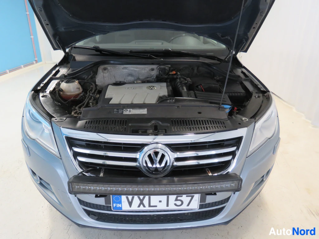 Edestä: Volkswagenin moottoritila avattuna, etusäleikö ja rekisterikilpi.