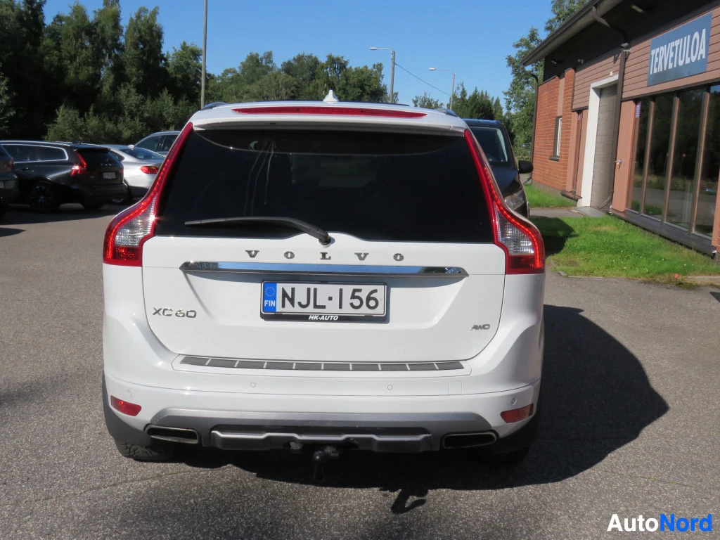 Takaa: Valkoisen Volvo XC60:n takaosa suoraan takaa, VOLVO- ja XC60-merkit sekä AWD-tunnus.