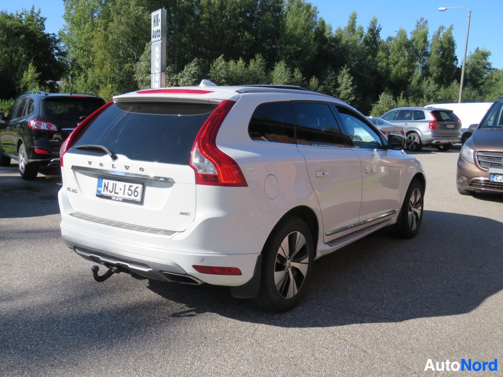 Takaviisto: Valkoisen Volvo XC60:n takakolmannes toiselta puolelta, vetokoukku ja kromilistat ovissa.