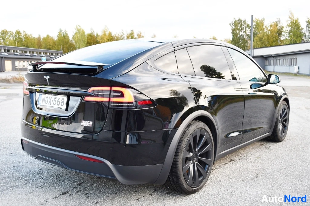 Takaviisto: Mustan SUV-auton takaosan oikeanpuoleinen kolmasosan kuvakulma, rekisteritunnus, tummat vanteet.