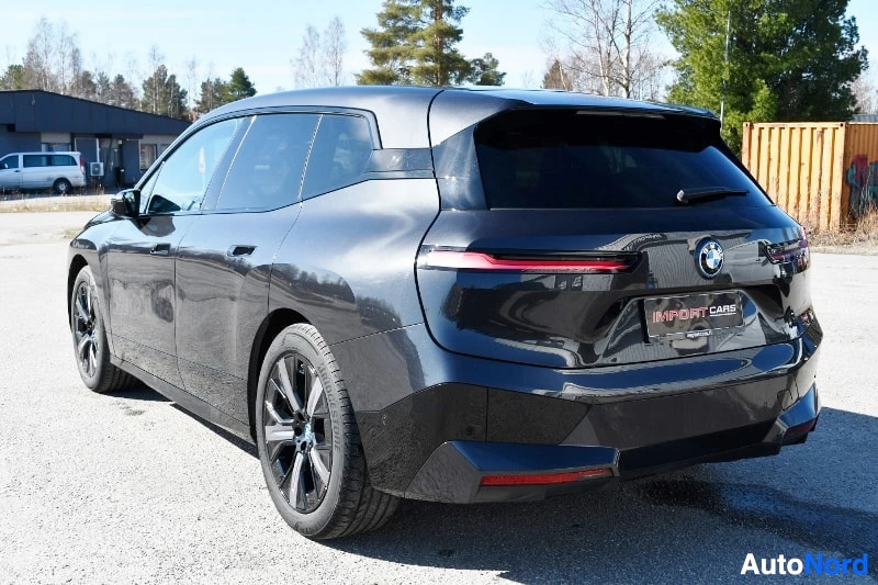 Takaviisto: Mustan auton takakolmannesvaaka oikealta; takavalo ja takapaneeli näkyvät oikealla, sivuprofiili vasemmalla.