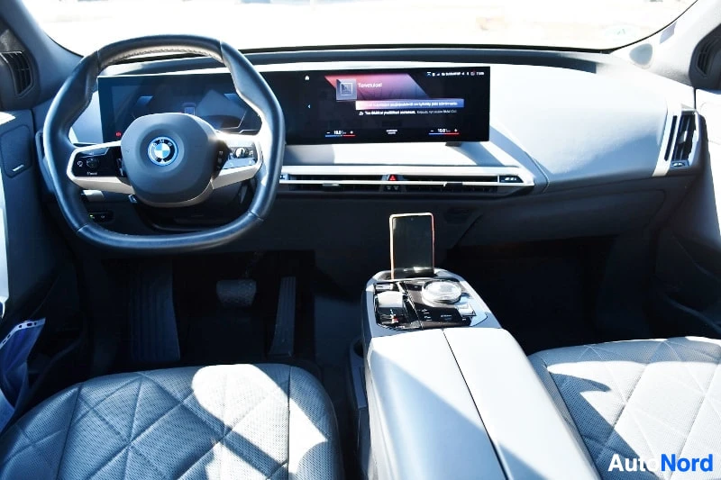 Muu: Sisätilakuva: ohjaamo, BMW-ohjauspyörä, kurvitettu mittaripaneeli, keskinäyttö ja keskikonsoli.