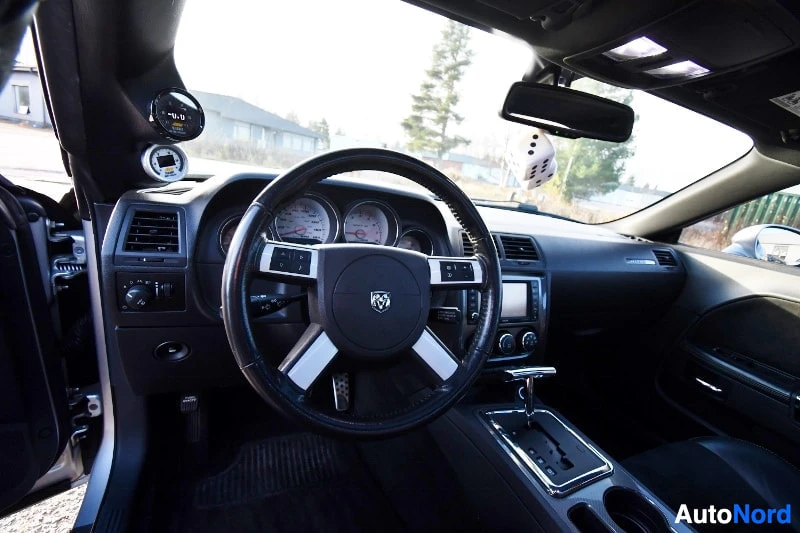 Ohjaamo: Auton sisätilat kuljettajan puolelta: ohjauspyörä, kojelauta ja automaattivaihteen valitsin.