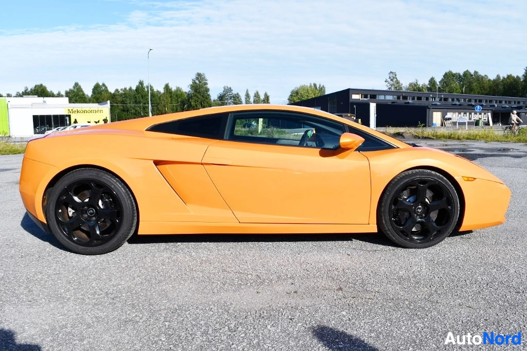 Sivulta: Oranssi Lamborghini-kupé sivulta, mustat vanteet, kokonaisuus näkyy