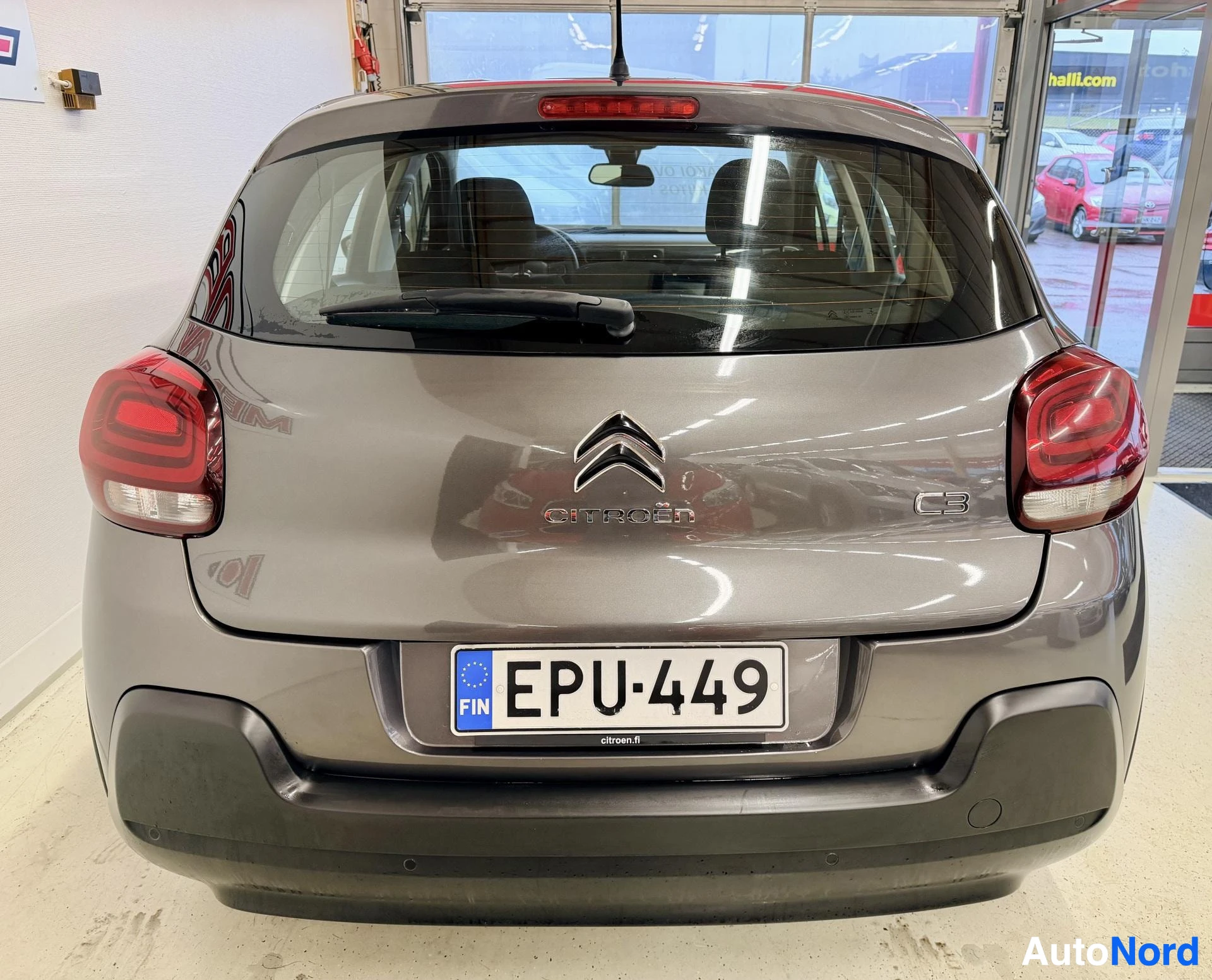 Takaa: Harmaan Citroën C3:n takaosa suoraan takaa; näkyvät C3-merkki, punaiset takavalot ja rekisteritunnus.
