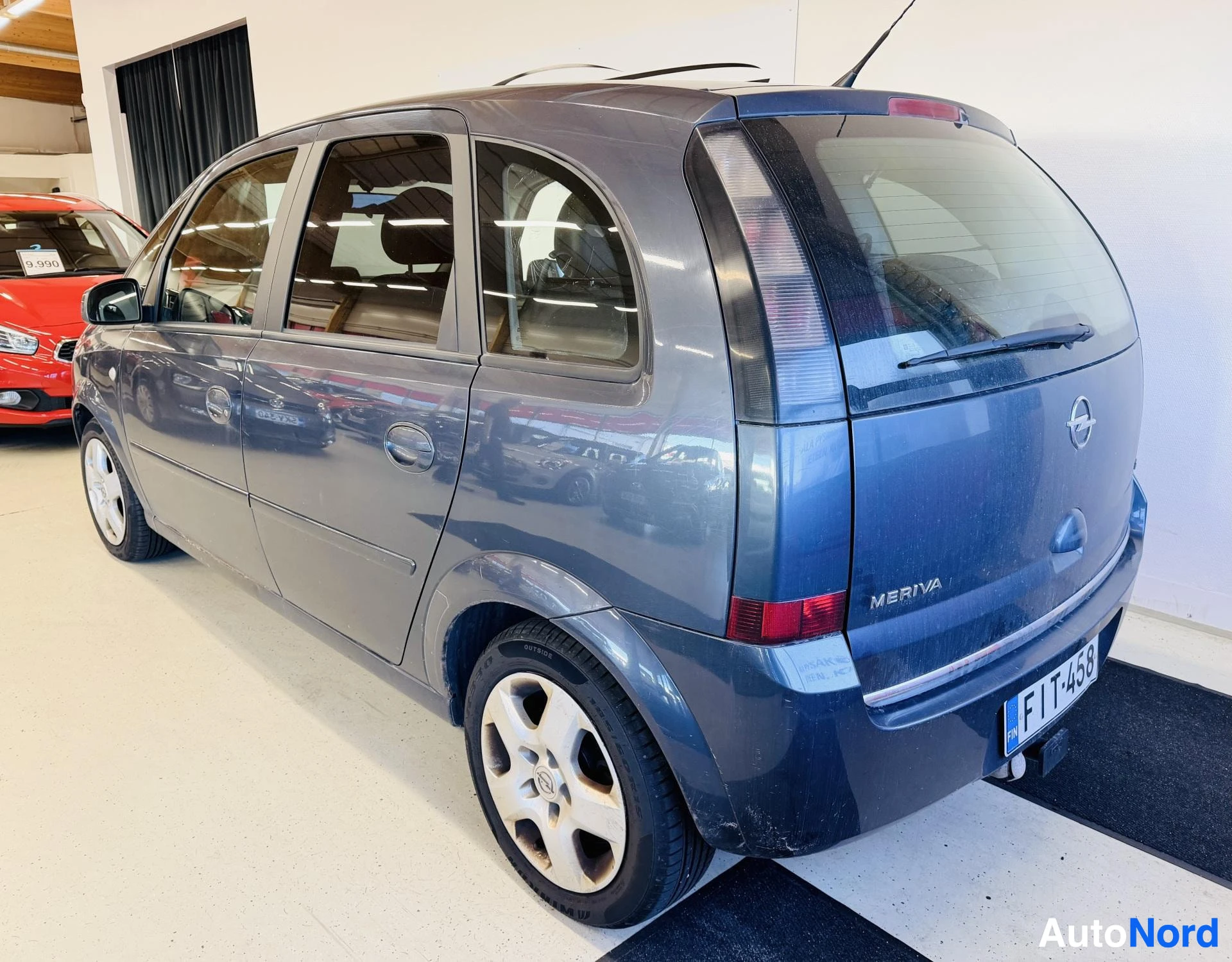 Takaviisto: Opel Meriva takakulmakuvassa: takaluukussa MERIVA-teksti ja Opel-tunnus, takavalot ja rekisterikilpi näkyvissä, vasen kylki osin kuvassa.