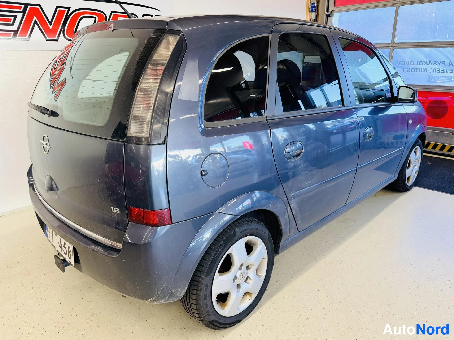 Takaviisto: Opel Meriva takakulmakuvassa oikealta: takaluukku Opel-tunnuksella ja 1.6-merkinnällä, takavalot, rekisterikilpi (osittain näkyvissä) ja oikea kylki näkyvissä.