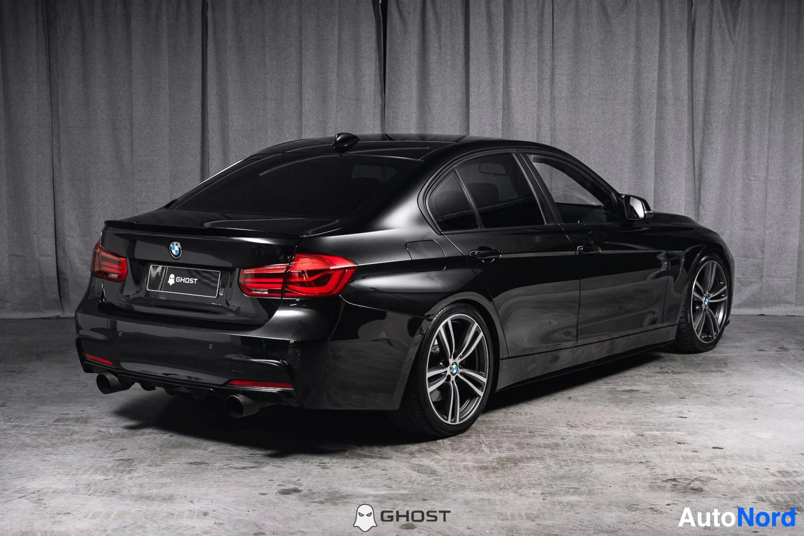 Takaviisto: Mustan BMW-sedanin takakulman kuva: punaiset takavalot, peräluukku ja takapuskuri vasemmalla, kylki ja kevytmetallivanteet oikealla.