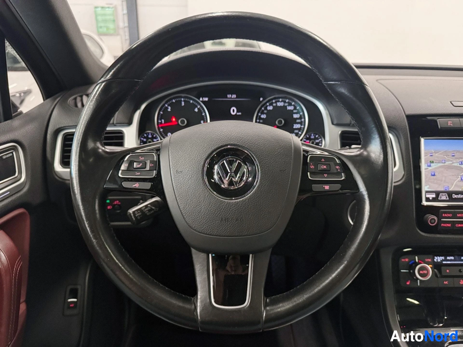 Ohjaamo: VW-ohjauspyörä, mittaristo ja navigointinäyttö keskikonsolissa.