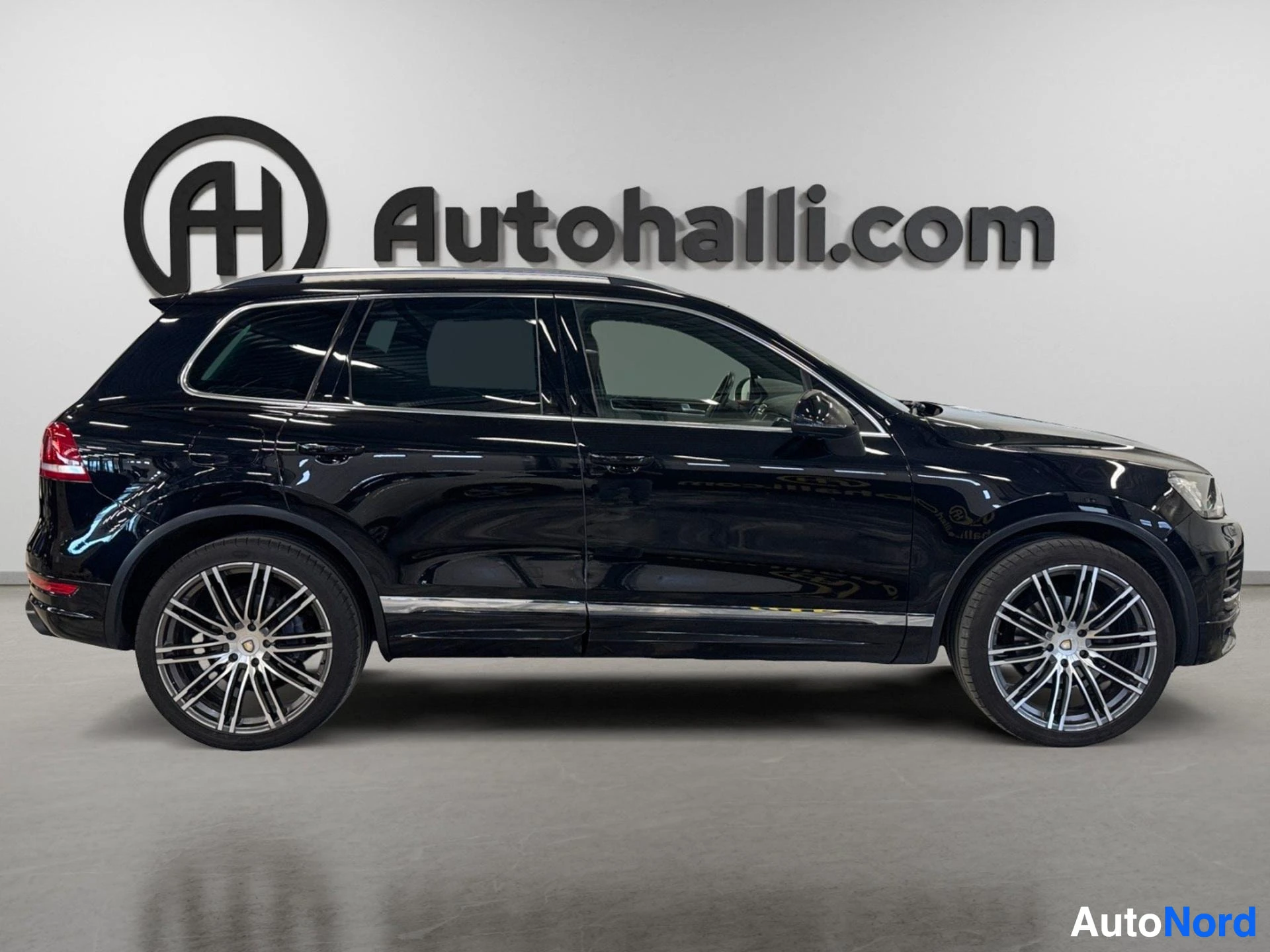 Takaviisto: Mustan Volkswagen SUV:n sivukuva vasemmalta, kromilista ovissa ja kattokaiteet.
