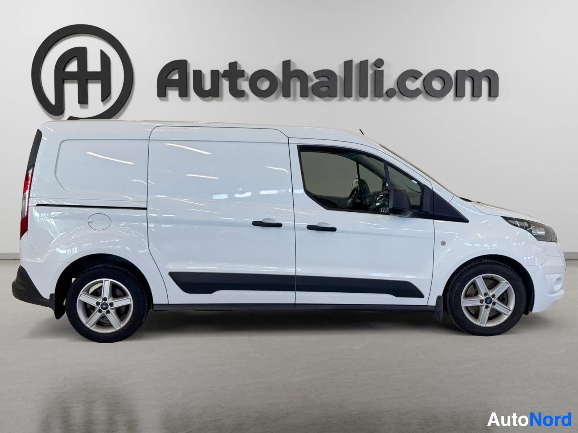Sivulta: Valkoisen Ford Transit Connect -pakettiauton sivunäkymä vasemmalta, liukusivia ja takapyörät näkyvissä.