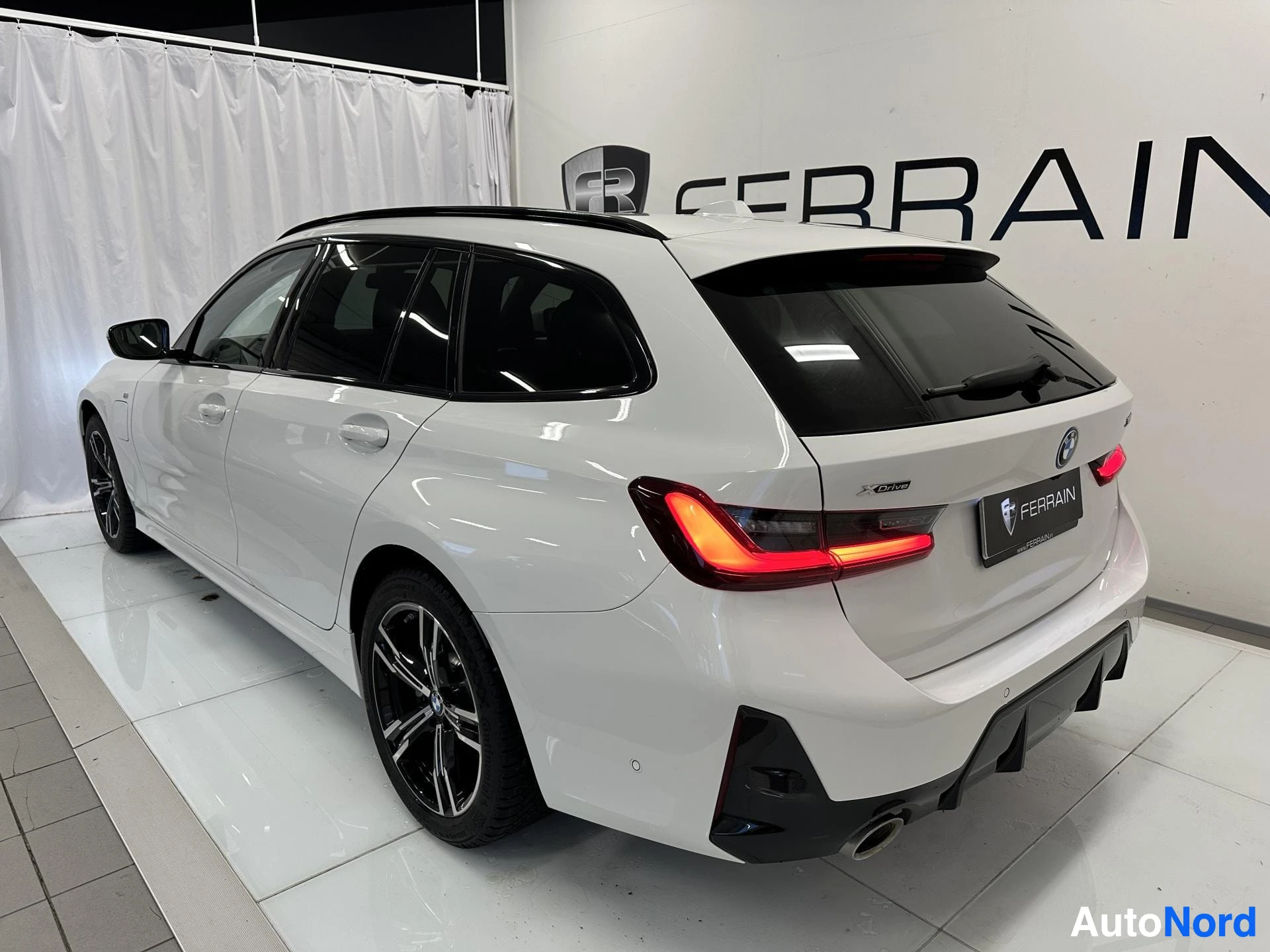 Takaviisto: BMW 3-sarjan farmari takaviistosta valkoisena.