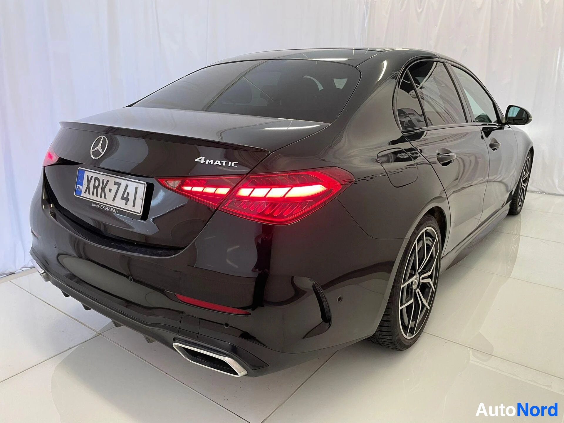 Takaviisto: Mercedes-Benz C:n takakulmakuva, tumma sedan, näkyvissä rekisterikilpi, 4MATIC-tunnus, takavalot ja kevytmetallivanteet.