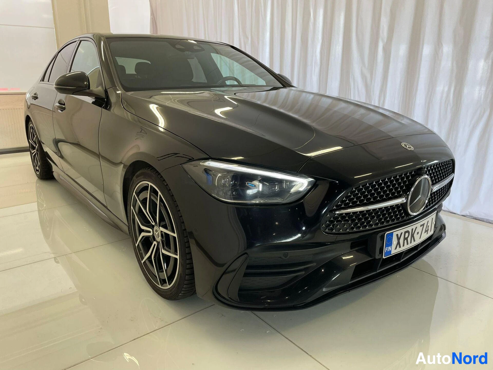Etuviisto, nokka oikealle: Mustan Mercedes-Benz C-sedanin etukulma näkyvissä etupuskuri,(maskirivi)...