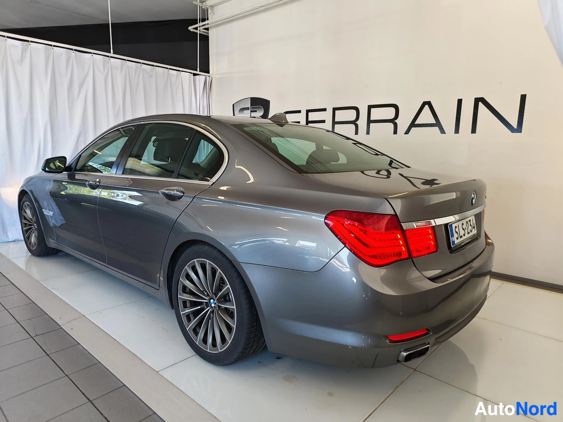Takaviisto: BMW-sedan takaosa ja sivu takakulmasta, hopeanharmaa korinen