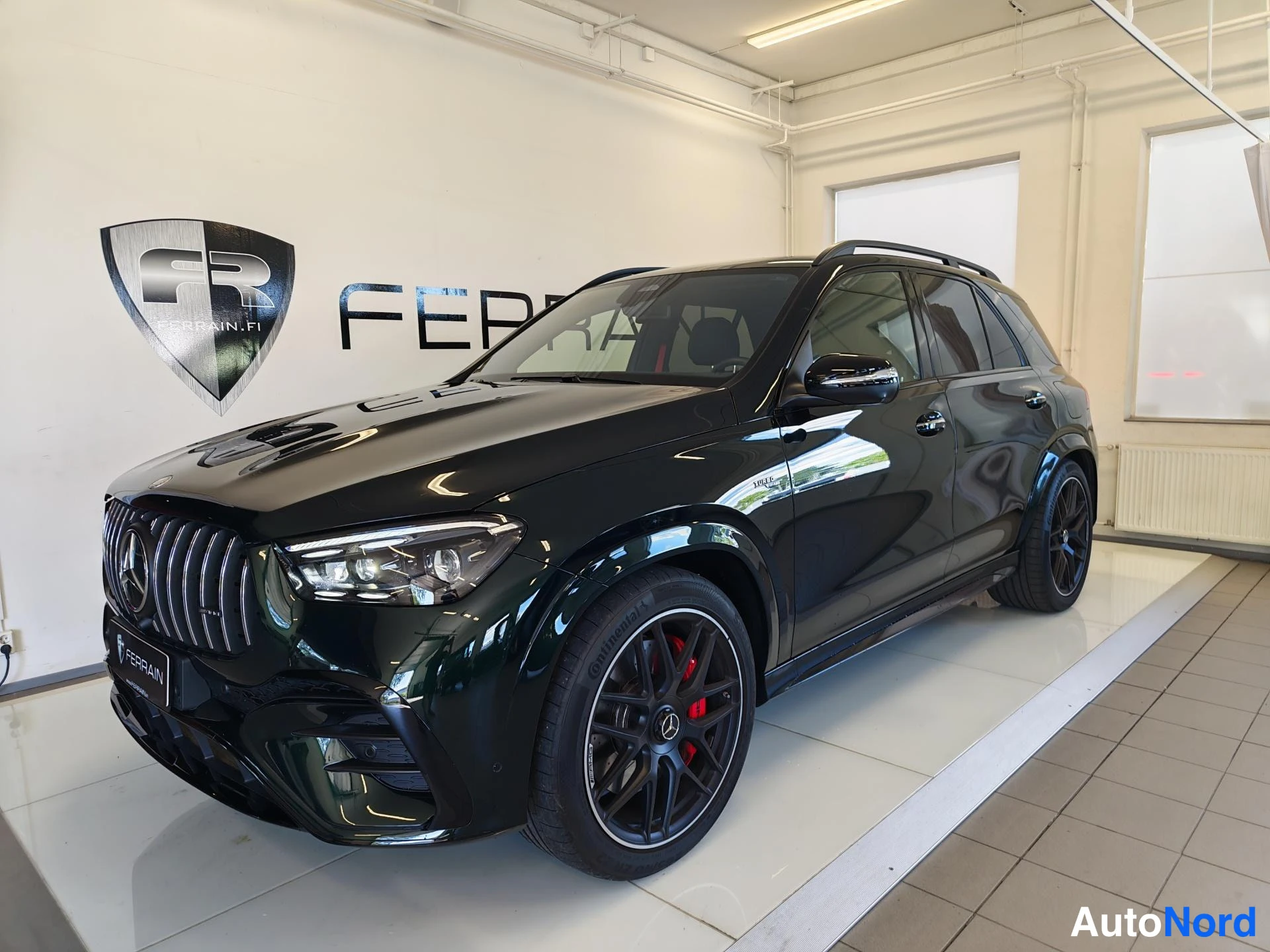 Etuviisto, nokka vasemmalle: Mercedes-Benz GLE -urheiluautomallin etunurkkakuva: tummanvihreä runko, AMG-tyylinen etusäleikkö, mustat kevytmetallivanteet ja punaiset jarrusatulat s