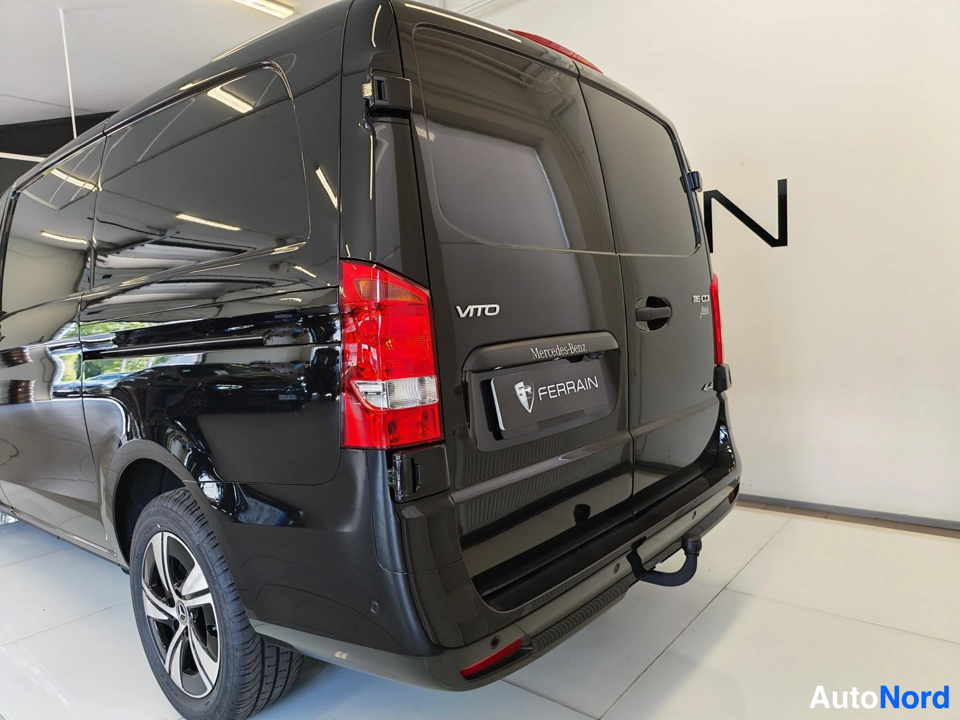 Takaviisto: Musta Mercedes-Benz Vito -pakettiauto seisoo autoliikkeessä valkoisilla lattioilla. Kuvassa näkyy auton takapää ja vasen kylki. Takaluukulla lukee VITO ja merkk
