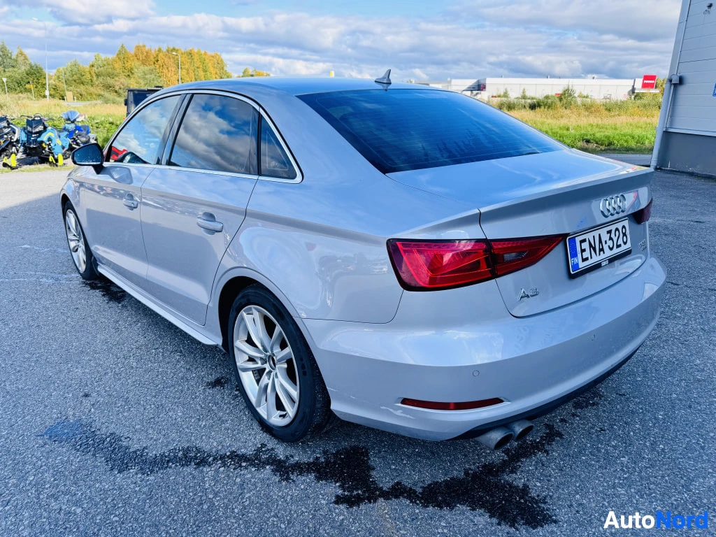 Takaviisto: Audi A3 Sedanin takakulma: hopeanharmaa korit, punaiset takavalot, rekisterikilpi.