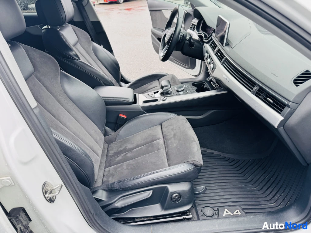 Muu: Audi A4:n etummat istuimet ja kojelauta: nahka-mokkaistuimet, ohjauspyörä, ylös nostettu tuloscreeni, automaattivaihteen valitsin ja reikämusteruokaa lattiamato