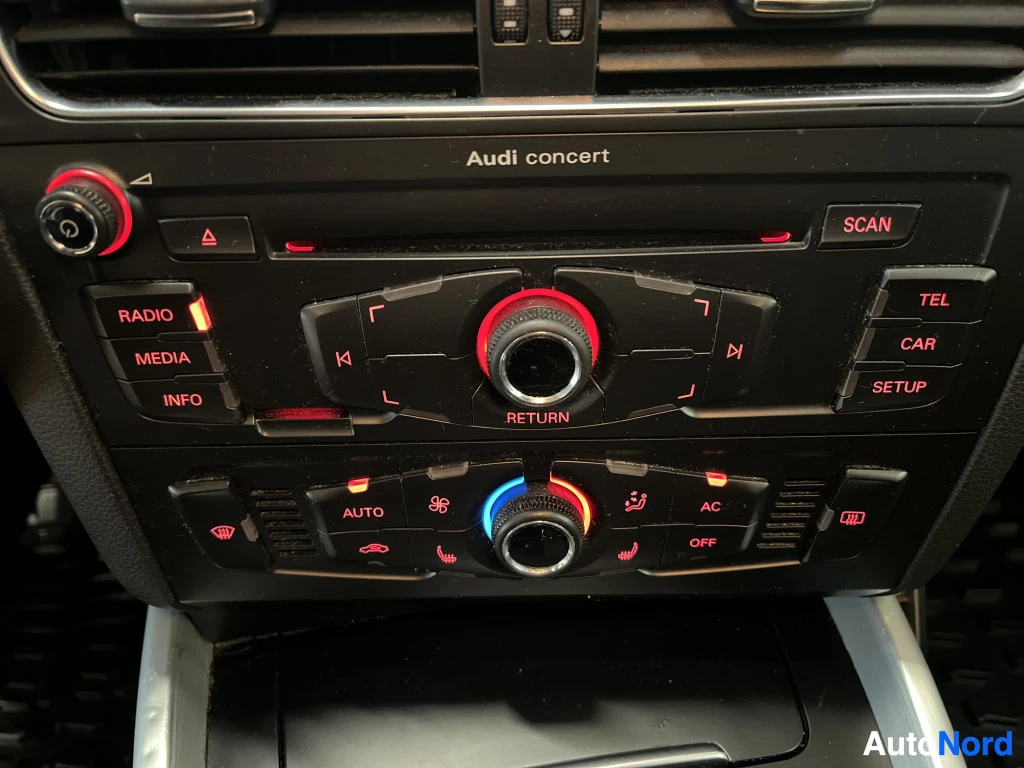 Yksityiskohta: Audi concert -radion ja automaattisen ilmastoinnin säätimet, joissa AC ja istuinlämmityksen painikkeet.