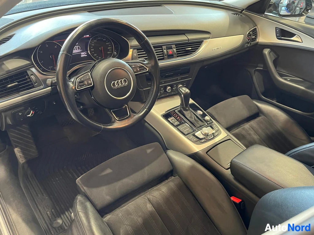 Muu: Audi A6:n ohjaamo vasemmalta katsottuna: kuljettajan istuin, ohjauspyörä, kojelauta ja keskikonsoli.