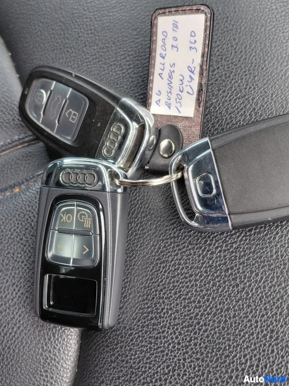 Muu: Kolme Audi-avainpesukettä nahkapinnalla ja käsin kirjoitettu lappu.