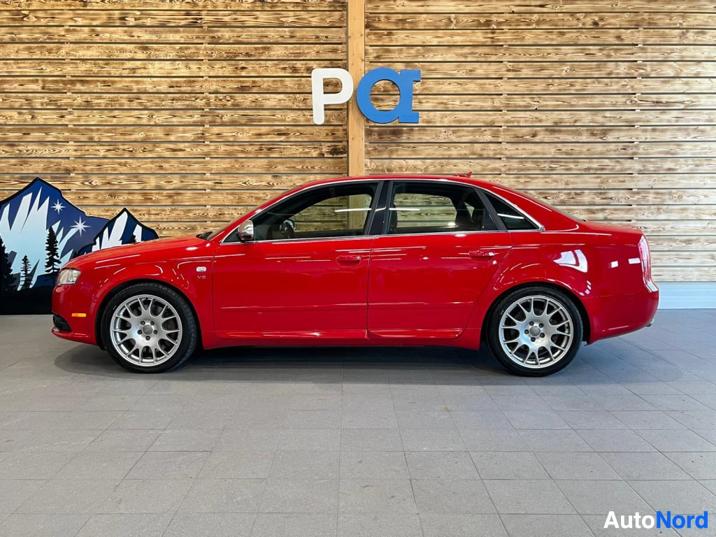 Sivulta: Punainen Audi S4 -sedan sivulta sisätiloissa, vasen kylki kokonaan näkyvissä.
