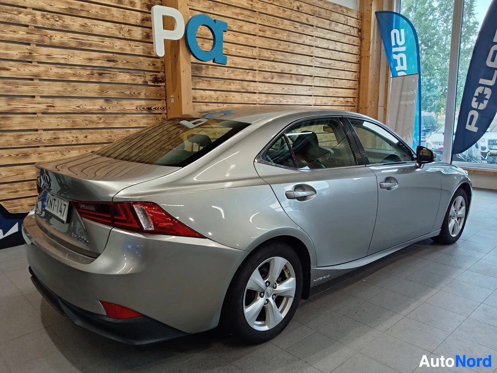 Takaviisto: Lexus IS -sedanin takakulma sisätiloissa; hopea kori, punaiset takavalot, rekisterikilpi ja vieheisiä alumiinivanteet.
