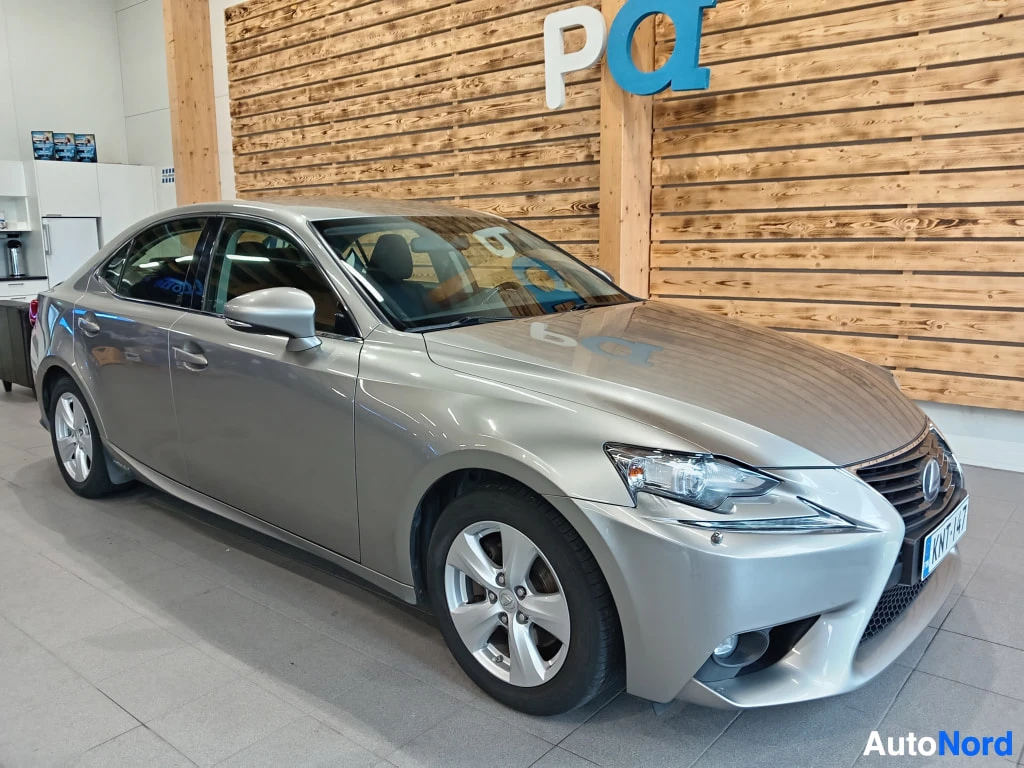 Etuviisto, nokka oikealle: Lexus IS -sedanin etukulma sisätiloissa; hopea kori, etusäleikkö, ajovalot, rekisterikilpi KNTG-141 ja alumiinivanteet.
