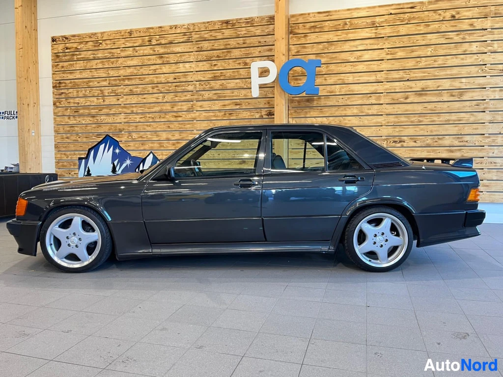 Sivulta: Sivukuva tummansinisestä Mercedes 190 -henkilöautosta sisätiloissa.