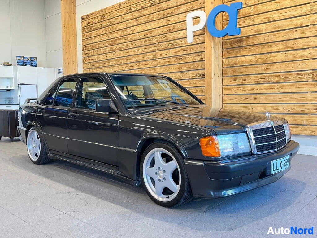Etuviisto, nokka oikealle: Mercedes-Benz 190 sedan etuviisto vasemmalta, tummanharmaa kori, kromiläuvikko ja kevytmetallivanteet, rekisteritunnus.