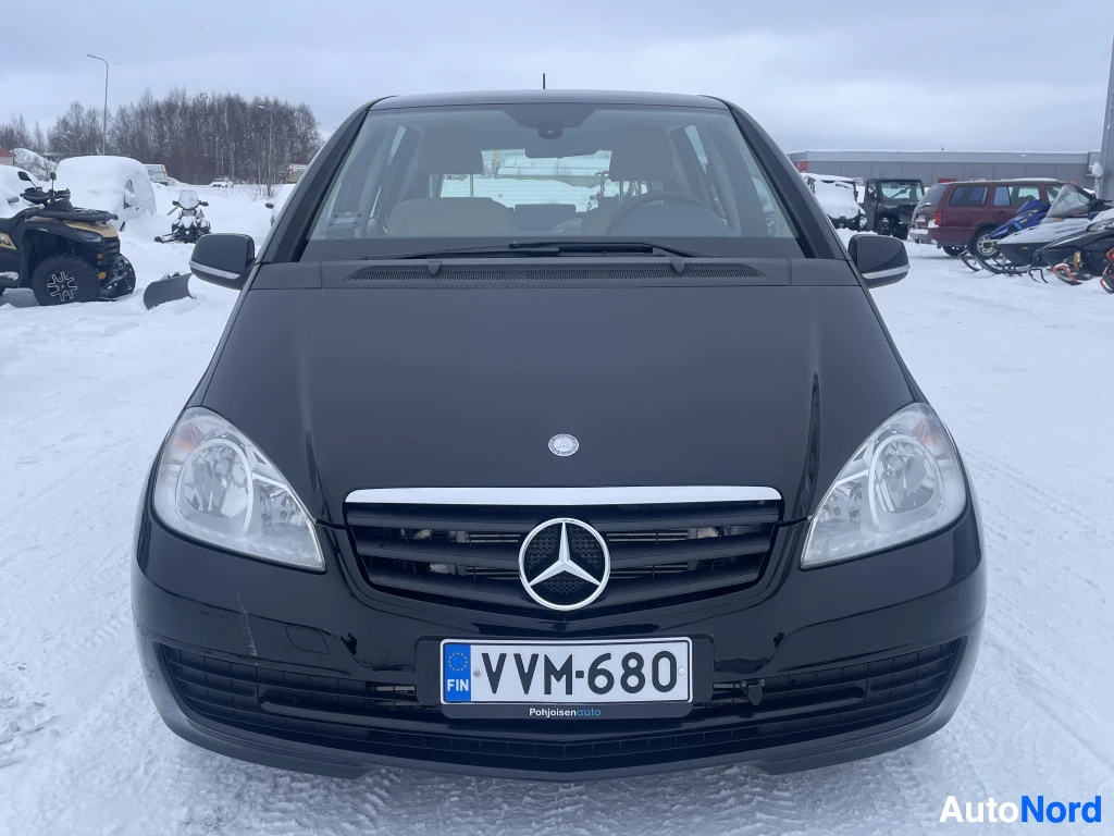 Edestä: Musta Mercedes-Benz A -henkilöauto suoraan edestä, rekisteritunnus, Mercedes-tähti etusäleikössä.