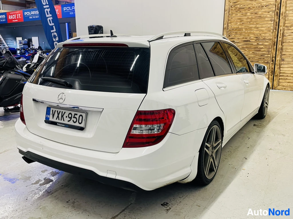 Takaviisto: Mercedes-Benz C-sarjan farmari takaviistosta, valkoinen kori, tummat tavaratilan lasit, rekisteritunnus.