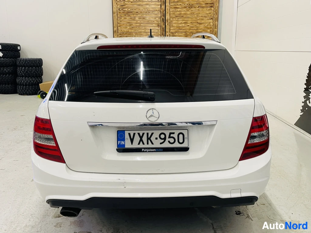 Takaa: Mercedes-Benz C-sarjan farmarin takaosa suoraan takaa, valkoinen koripohja, rekisteritunnus.
